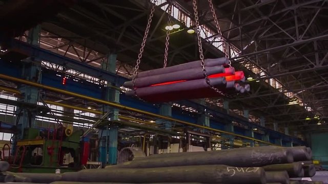 Manufacture of rails for trains and freight wagon, boxcars. Rail manufacturing plant. Stack of steel round bar - iron metal rail lines material for industry construction in warehouse. the big press