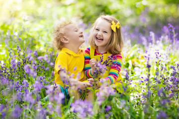 Kids playing in blooming garden with bluebell flowers
