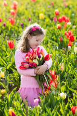 Little girl in tulip flower garden