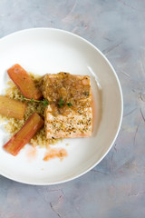 Grilled salmon with quinoa and rhubarb sauce. Gray background, white plate. Isolated.