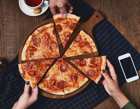 Eating Pizza. Group Of Friends Sharing Pizza Together. People Hands Taking  Slices Of Pepperoni Pizza. Fast Food, Friendship, Leisure, Lifestyle. Stock  Photo