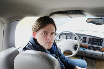 Portrait of a young man inside a car interior