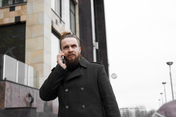 Modern serious beard male tourist call friend to ask way. young hipster guy dressed in trendy casual wear strolling on city street communicating in roaming.