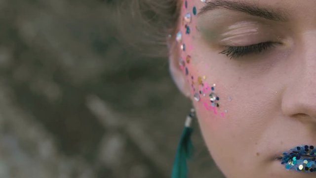 Close up shot of girl's eye with creative makeup of peahen. Slowly