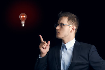 A man in a business suit on a black background indicates a stuck light bulb. "What if?"