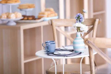Flowers and cutlery on table in cafe