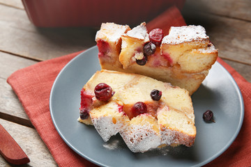 Plate with slices of bread pudding on wooden table