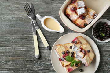 Plate with pieces of baked bread pudding  on wooden table