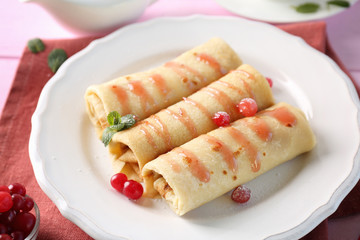 Plate with delicious pancakes and cranberry on table