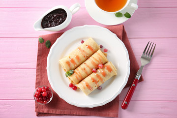 Plate with delicious pancakes and cranberry on table