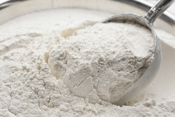 Taking wheat flour from bowl, closeup