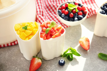 Cups with tasty homemade yogurt on kitchen table