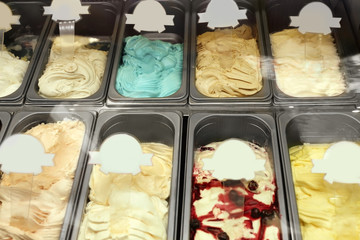 Showcase of different ice cream in metal tubs, closeup