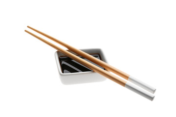 Bowl with tasty soy sauce and chopsticks on white background