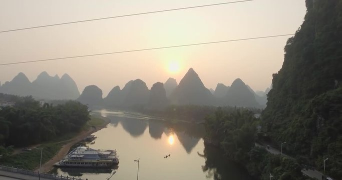 Top view of amaizing famous Yangshuo valley in Guilin, Guangxi, China. Aerial View of beautiful sunrise over bridge and Yulong or Dragon River. Overpopulation concept, beauty in nature