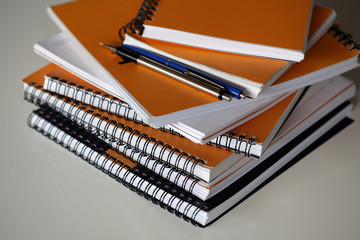 Stack of ring binder notebooks on white background.
