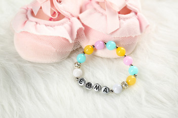 Composition with baby name bracelet on white fluffy background