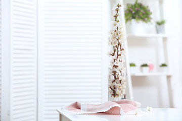Vase with blossoming spring branches on table