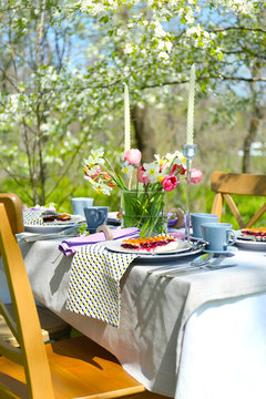 Table setting and cage with flowers in garden