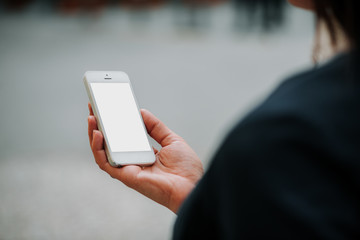 Woman using smartphone outdoors. Woman using smartphone white screen. Woman hand holding smartphone.