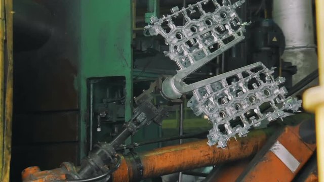 robot shifts metallic details for car engine in a automobile factory
