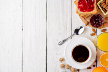 Breakfast table with healthy tasty ingredients. Coffee, toast, jam, almonds, orange juice and fruit...