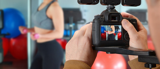 Man recording with camera girl in the gym while she training