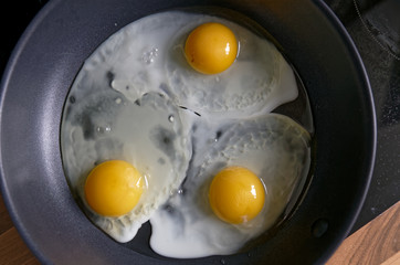 Fried eggs from a hen's egg in a frying pan with yellow yolks