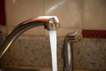 Running water out of a faucet.