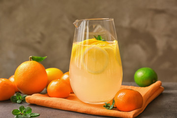 Glass with refreshing citrus fruits cocktail on grunge background