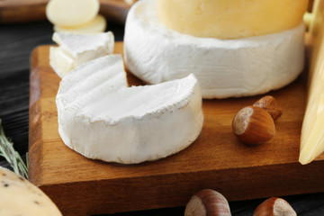 Composition with variety of cheese on wooden board