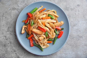 Blue plate with delicious rice noodle on grey table
