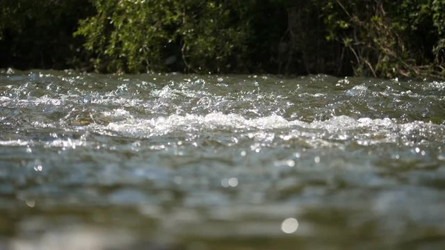 Super slow motion water floating down a river, in HD