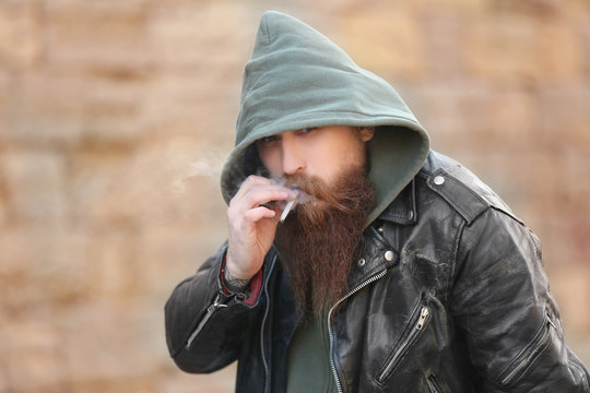 Bearded man smoking weed outdoors