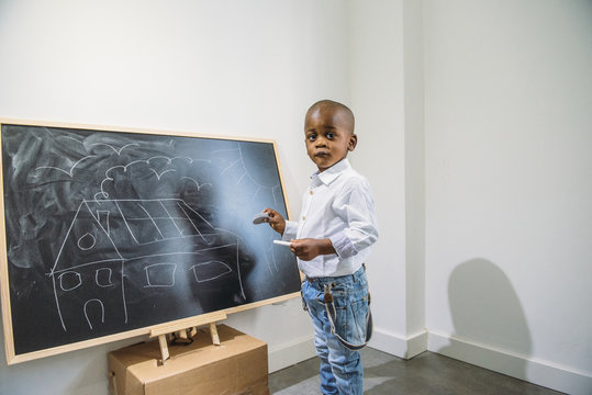 Little boy in class drawing blackboard