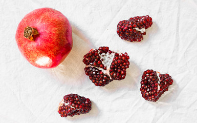 Ripe and red pomegranate fruit with seeds against white background