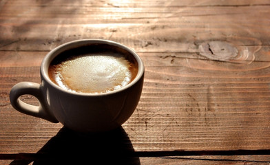 Cup of caffee on wooden table.