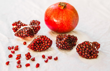 Ripe and red pomegranate fruit with seeds against white background