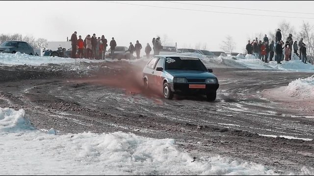 Rally car goes on dirt. ars go off-roading in race. Rally car going down slope in race at Sun City. Dirty rural road with puddles and mud under dark dramatic stormy sky, SUV car goes far away.