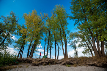 Young lady standing by the tent and looking to the trees