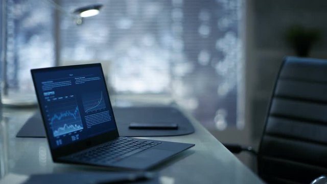 Footage of a Modern Office with Leather Chair, Wood and Glass Table with Laptop on It. Workspace is Made with Dark Overtones. Shot on RED EPIC-W 8K Helium Cinema Camera.