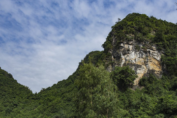 Fototapeta na wymiar Green mountain with sandstone rock face, Ninh Binh, Vietnam