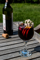 Sangria Cocktail in wine glass with lemon, cinnamon, fruits and ice.