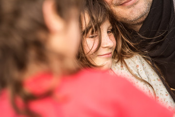 outdoor portrait of young child girl with her dad on natural background