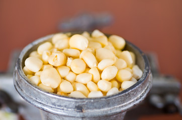 A close up from a metalic mill with some corn kernels