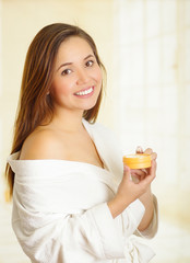 Obraz na płótnie Canvas Beautiful smiling young woman holding a cream body