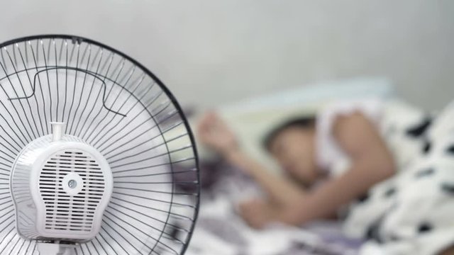Little girl sleeping with fan blowing

