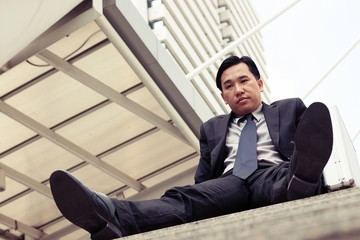 Unhappy business man is sitting at stairs