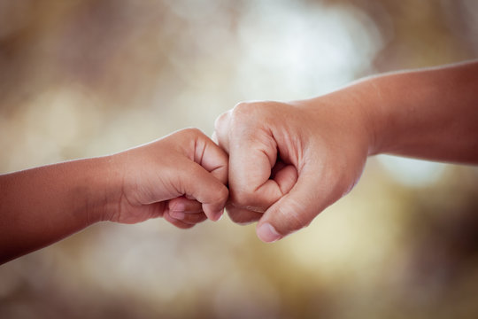 mother and kid daughter are fist bumping in vintage color tone