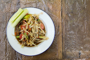 Thai papaya salad (Somtum) on wooden background